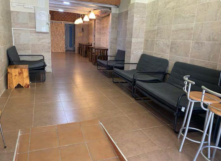 Zona de estar con sofás y taburetes